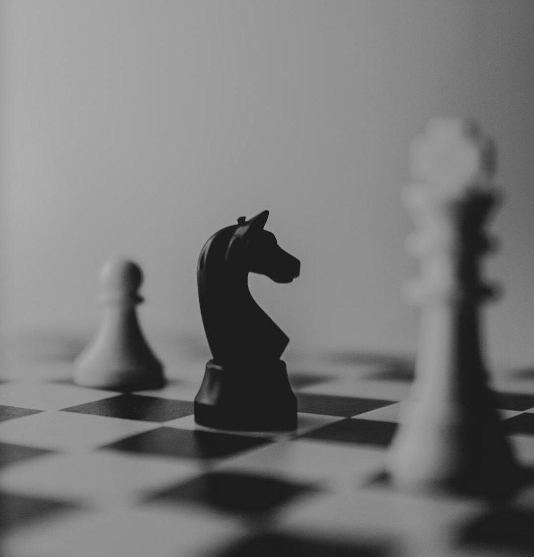 Chess pieces on a board in dramatic light